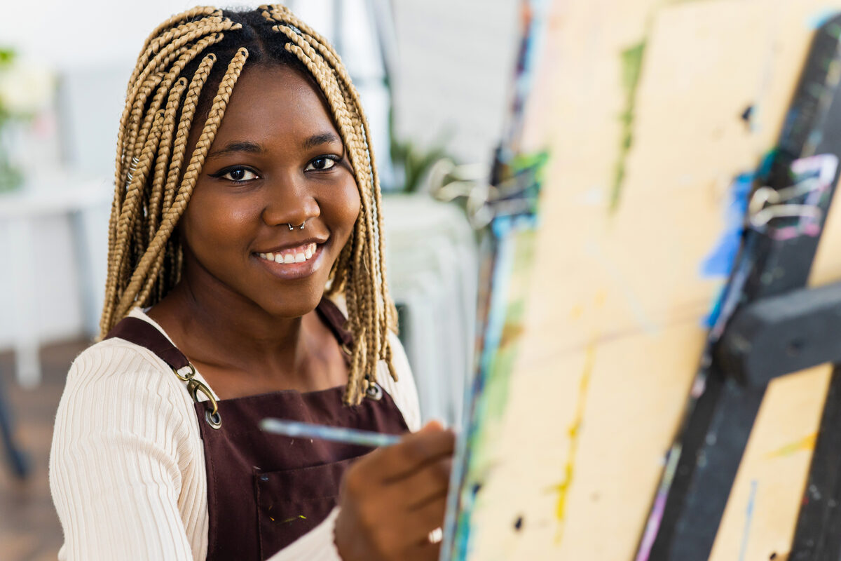 Simone Fields smiling while painting