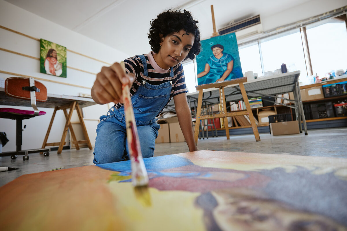 Portrait of featured artist Julian Boyd at work on a canvas